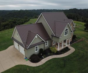 Home with brown standing seam metal roof and green siding.