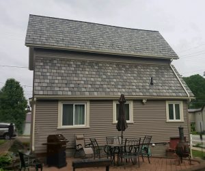 Home with a gray asphalt shingle roof and brown siding.